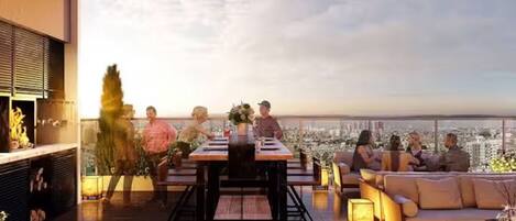 A rooftop terrace with a city view, a dining table, and seating arrangements.