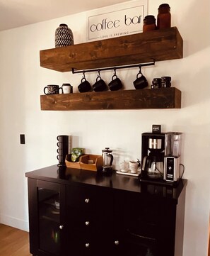 Una barra de café con estantes, tazas y equipo para preparar café.