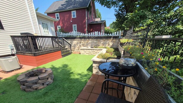 A backyard with a fire pit, a patio table, and chairs. - Quaint home that sleeps 9, 3 blocks from the Beach. Private back yard with bar. (Culver)