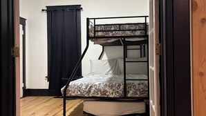 A room with a bunk bed, a ceiling fan, and a wooden floor. - Quaint home that sleeps 9, 3 blocks from the Beach. Private back yard with bar. (Culver)