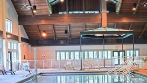 An indoor swimming pool with a clear view of the pool area, a covered seating area, and a staircase leading to a higher level. - Starved Rock Lodge & Conference Center (Oglesby)