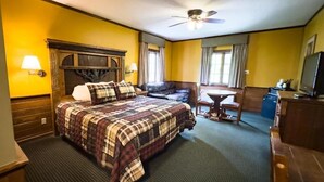 A hotel room with a bed, a desk, a chair, a television, and a ceiling fan. - Starved Rock Lodge & Conference Center (Oglesby)