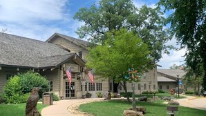 A building with a stone facade, American flags, and a statue of an eagle. - Starved Rock Lodge & Conference Center (Oglesby)