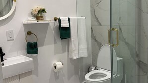 Une salle de bain moderne avec une douche à parois de verre, des toilettes, un lavabo et un meuble-lavabo.