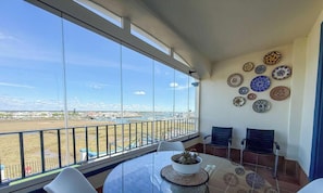 Ein Balkon mit Tisch, Stühlen und Blick auf die Landschaft.
