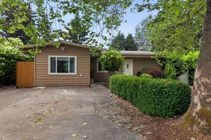 A single-story house with a front porch, a small attached garage, and a well-maintained lawn.