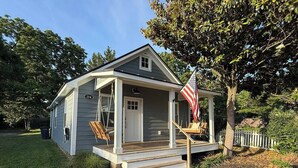 Une maison de plain-pied avec un porche, une boîte aux lettres et un drapeau américain.
