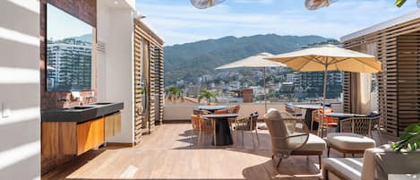 A modern balcony with a view of a cityscape and mountains.