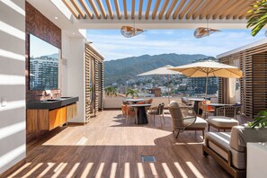A modern balcony with a view of a cityscape and mountains. - Luxury 2B Romantic Zone Condo , Rooftop Pool, 2-Min Walk to Beach (Puerto Vallarta)