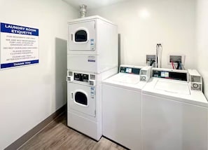 A laundry room with a sign detailing etiquette, a stacked washer and dryer, and a control panel. - Galactic Getaway - 15 Min to Midway - Easy Access to Chicago (Berwyn)