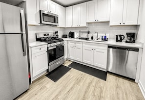 A modern kitchen with white cabinets, stainless steel appliances, and a wood floor. - Galactic Getaway - 15 Min to Midway - Easy Access to Chicago (Berwyn)