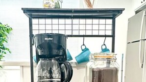 Un plan de travail de cuisine avec une machine à café, un grille-pain, une bouilloire et divers aliments.