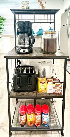 Eine Küchenarbeitsplatte mit Kaffeemaschine, Toaster, Wasserkocher und verschiedenen Lebensmitteln.