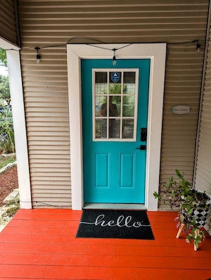 A turquoise door with a window, a 'hello' mat, and a 'Casa Eastside' sign. - Fabulous  2-bedroom house near Downtown San Antonio! (San Antonio)