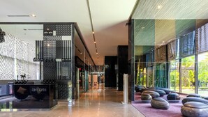 Un hall d’entrée moderne avec une cloison en verre, un espace salon et un comptoir d’accueil portant l’inscription « RHYTHM ».