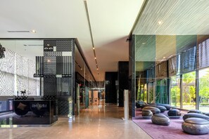 A modern lobby with a glass partition, seating area, and a reception desk labeled 'RHYTHM.' - 5 Min to Metro, Washer & Dryer, Essentials, Gym (Khet Khlong Toei)