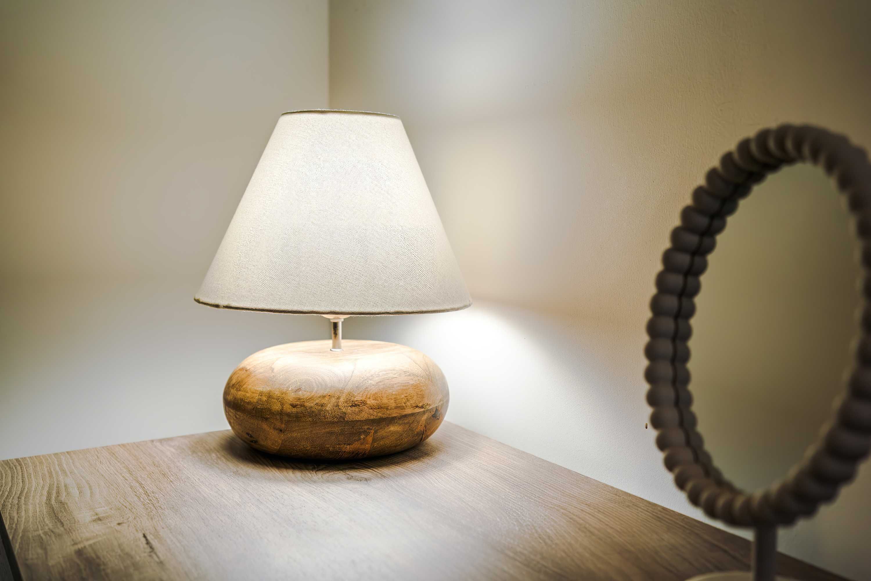 A wooden table with a lamp and a mirror.