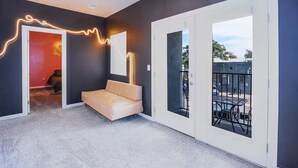 Un interno moderno con un divano, un tavolo da pranzo e un balcone con vista.