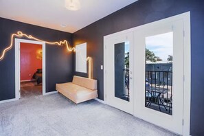Un interior moderno con un sofá, una mesa de comedor y un balcón con vistas.