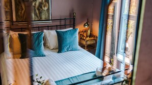 Una cama con ropa de cama a rayas, cabecera y almohadas.