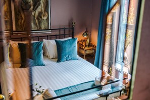 A bed with striped bedding, a headboard, and pillows. - Stylish Retro Retreat in Manchester 4 Bed Home (Manchester)