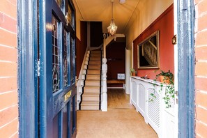 A staircase with a white balustrade, a chandelier, and a sign on the wall. - Stylish Retro Retreat in Manchester 4 Bed Home (Manchester)