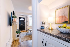 A kitchen with a granite countertop, a bowl of fruit, a lamp, and a framed picture on the wall. - Spacious 3 Bed Perfect for Families and Groups (Nantwich)