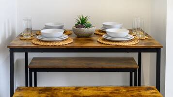 A dining table with white bowls, glasses, and a central plant.