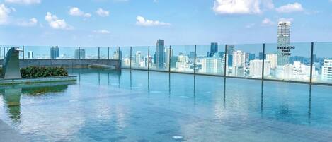 A rooftop infinity pool with a city skyline view.