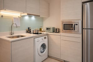 Eine moderne Küche mit Einbauwaschmaschine, Mikrowelle und Toaster.