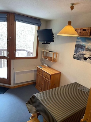 A room with a television, a desk, a chair, a bed, a window with a view, and a ceiling fan. - 200 meters from the ski slopes, 1st floor, balcony, TV, 23 m², Peisey-Vallandry (Peisey-Nancroix)