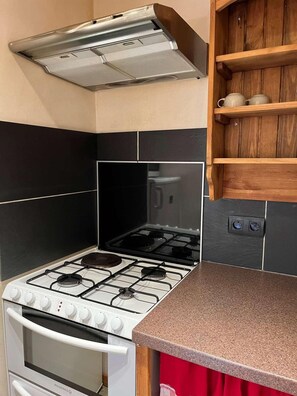 A kitchen with a stove, oven, and a wooden shelf above. - Fireplace or stove, parking, tv, 40m², Peisey-Vallandry (Peisey-Nancroix)