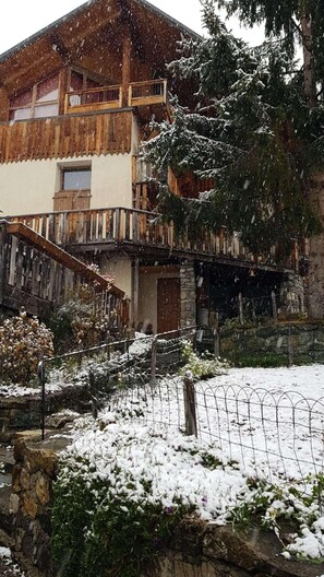 A rustic chalet with a wooden balcony, stone walls, and a snow-covered garden. - Fireplace or stove, parking, tv, 40m², Peisey-Vallandry (Peisey-Nancroix)