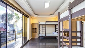 A room with bunk beds, a sliding glass door, and a ceiling light.