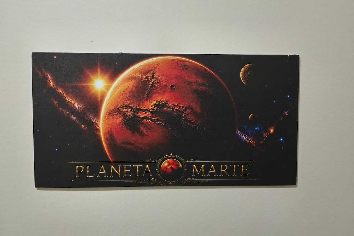 Póster con temática espacial que muestra el texto 'PLANETA MARTE' y la representación de un planeta con anillos y cuerpos celestes.