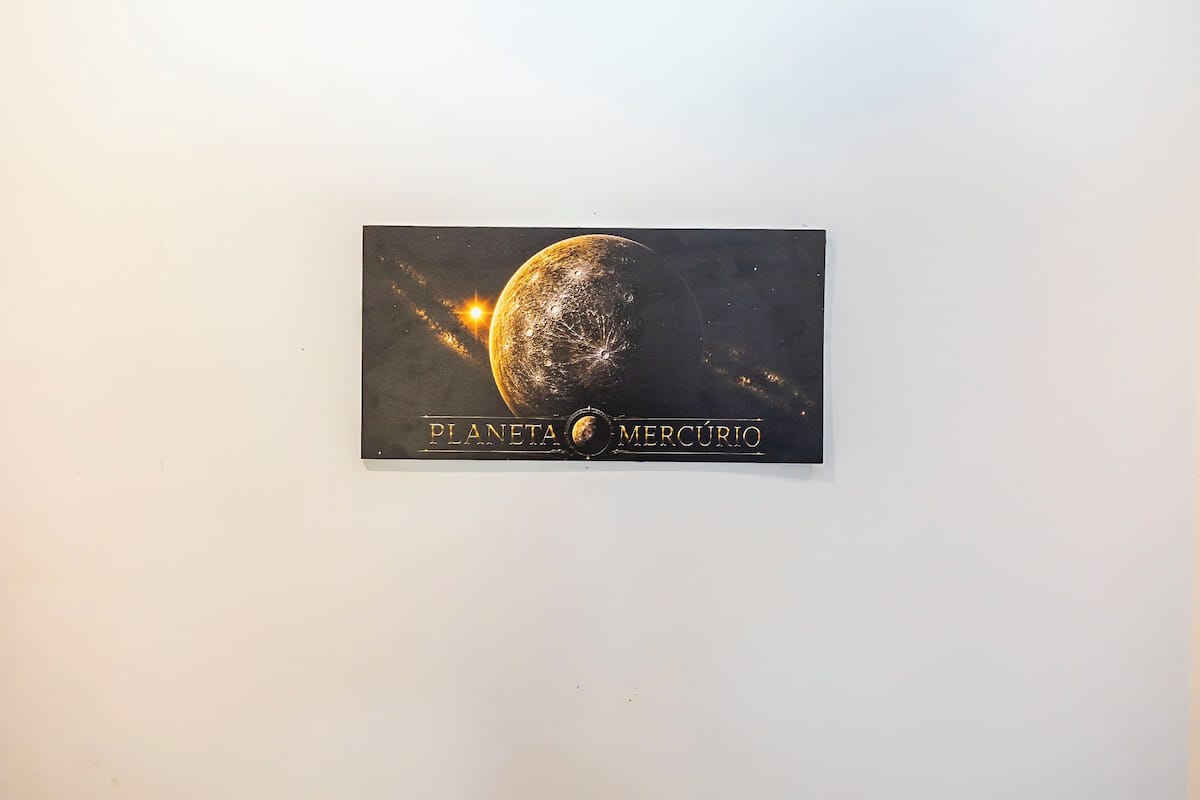 Un cartel montado en la pared con una representación de un planeta y el texto 'PLANETA MERCÚRIO'.