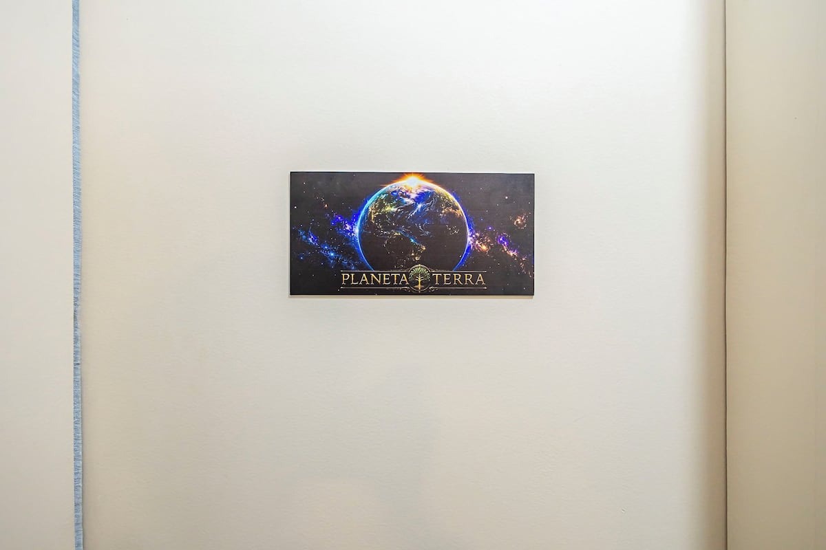 Una pared con un cuadro enmarcado de un planeta y el texto 'PLANETA TERRA'.