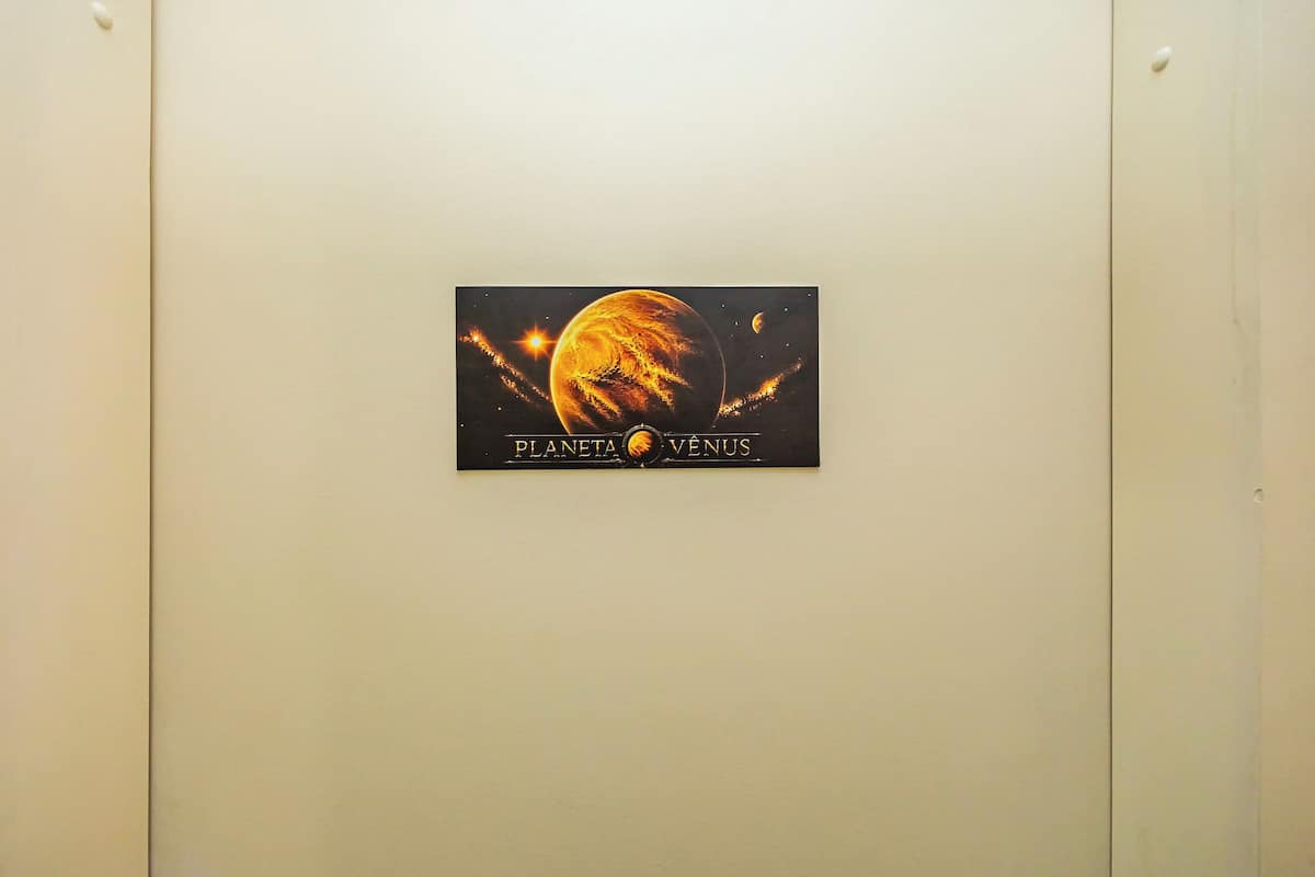 Una pared con un cartel enmarcado que dice 'PLANETA VENUS' y muestra un planeta.