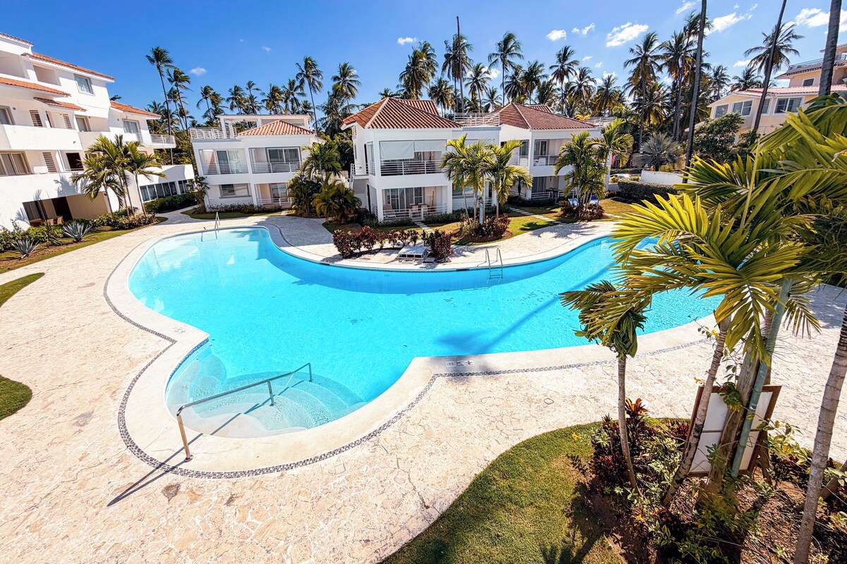 Un resort con piscina, palme e edifici a più piani.