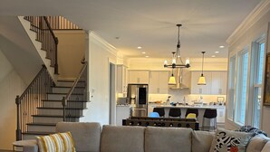 Una sala de estar moderna con un sofá modular, una mesa de centro y una escalera.