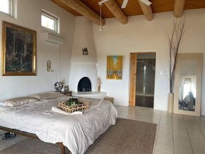 A bedroom with a bed, a fireplace, a painting, and a mirror. - Casa Encantado in Eldorado (Santa Fe)