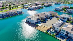 A residential area with houses along a waterfront, featuring a central open space and a dock. - Sunset by the Lake | Heated Pool, Spa & Arcade (Indio)
