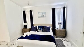 A neatly arranged hotel room with a bed, two bedside tables, a lamp, and a painting on the wall.