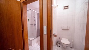 Un bagno con doccia, WC e lavandino.