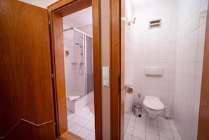 Ein Badezimmer mit Dusche, Toilette und Waschbecken.