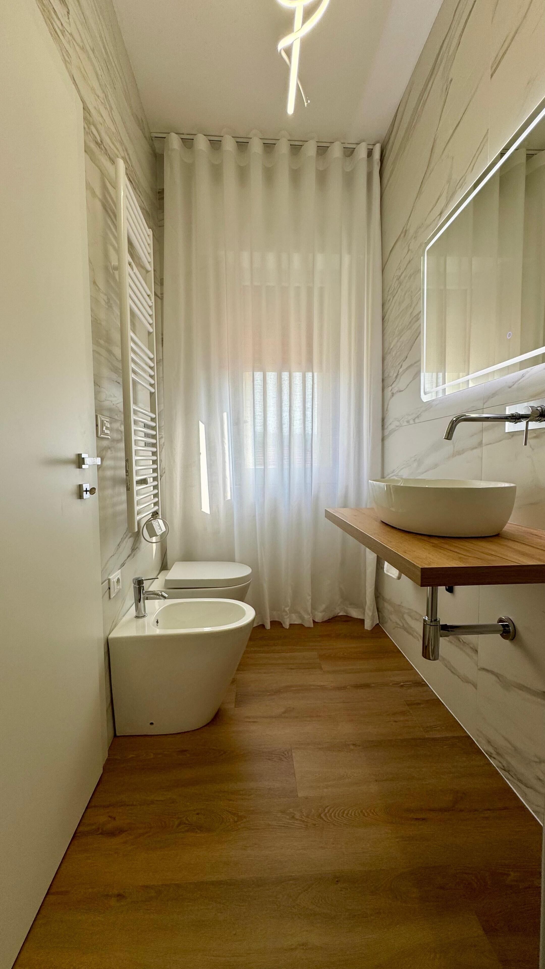 A bathroom with a bathtub, a toilet, a sink, and a mirror.