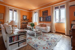 A living room with a sofa, coffee table, and bookshelves. - Historic Dorsoduro Apartment with Balcony Near Guggenheim & Zattere (Venezia)
