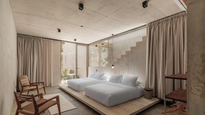 A modern bedroom with a large bed, a wooden chair, and a small table. - Casa Talá by Lumina (Santa María Colotepec)