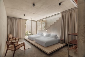 A modern bedroom with a large bed, a wooden chair, and a small table. - Casa Talá by Lumina (Santa María Colotepec)