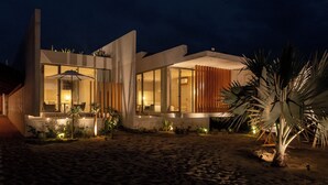 A modern house with large windows, a patio, and a palm tree. - Casa Talá by Lumina (Santa María Colotepec)